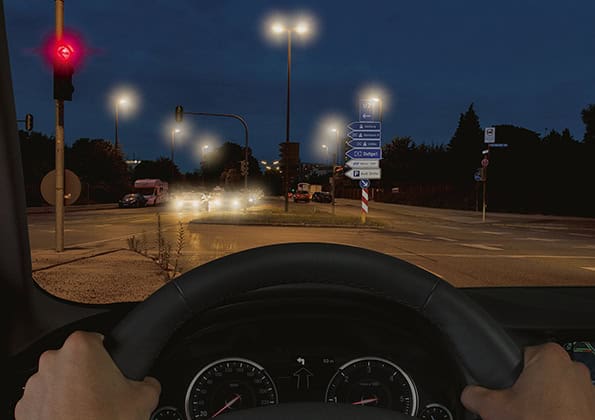 Nachtfahrt ohne Blendschutz-Veredelung: starke Lichthöfe um Scheinwerfer und Ampel